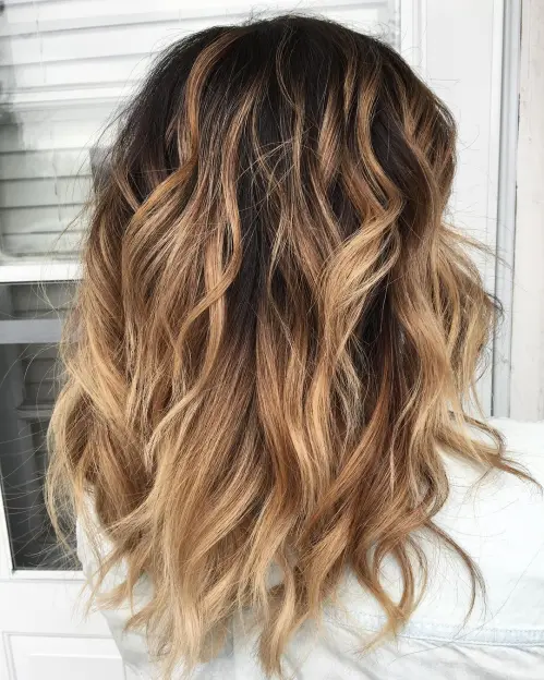 Mid-Length Layered Hairstyle with Tousled Waves Medium Wavy Bronde Balayage Hairstyle