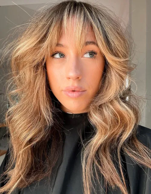 Medium Length Wavy Hair and Choppy Bangs Eye Skimming Bangs and Voluminous Curls
