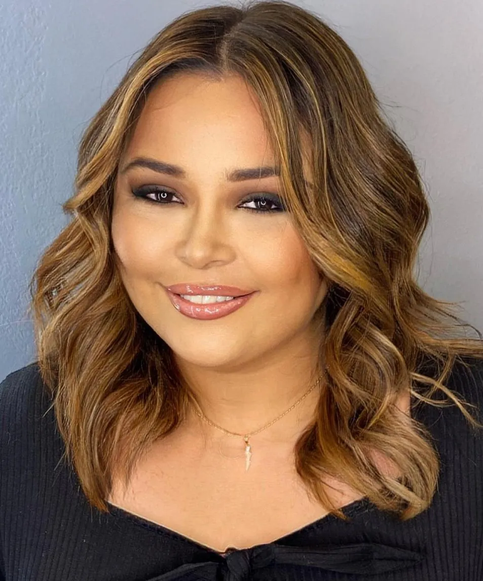 Collarbone-Grazing Hairstyle with Warm Highlights Medium Wavy Hair with Gold Highlights